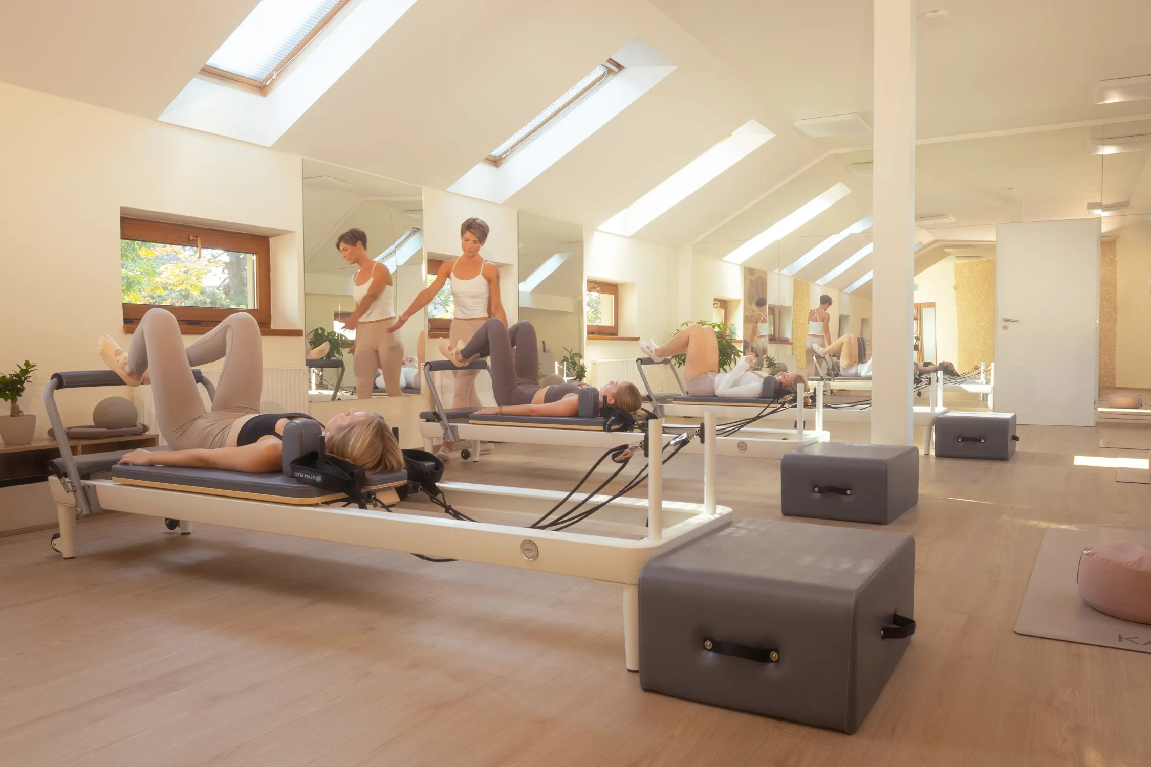 Skupinová lekce Pilates Reformer v prosvětleném studiu